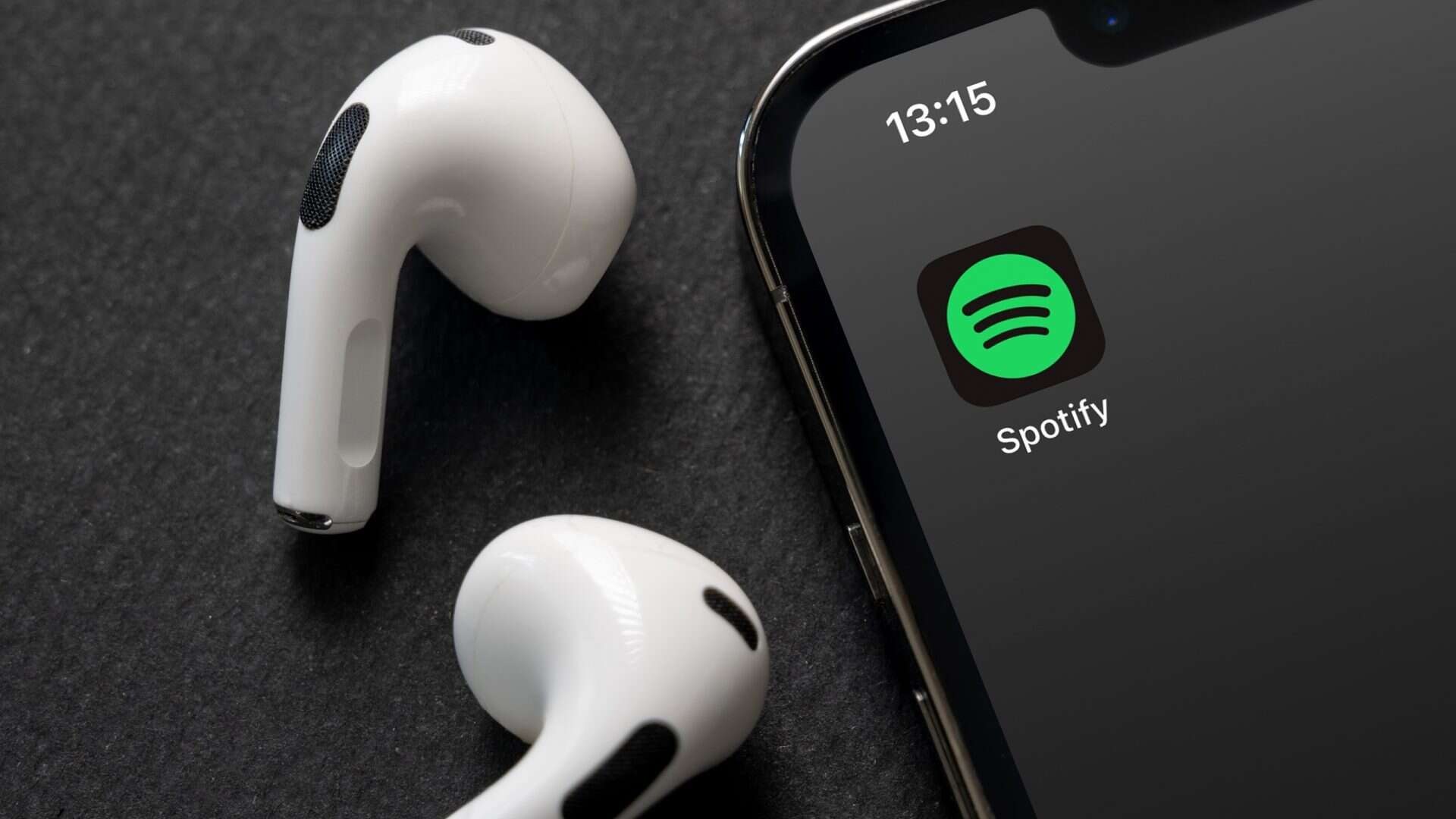 Fone de ouvido ao lado de um smartphone com o logo do Spotify