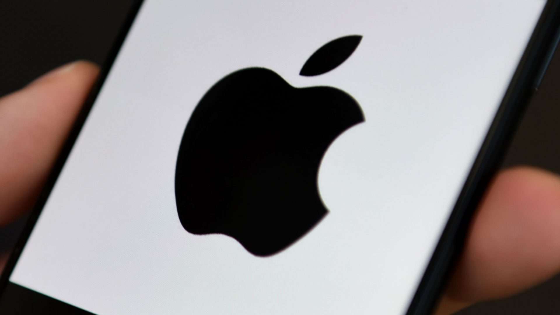 Logo da Apple em preto em tela de smartphone branca
