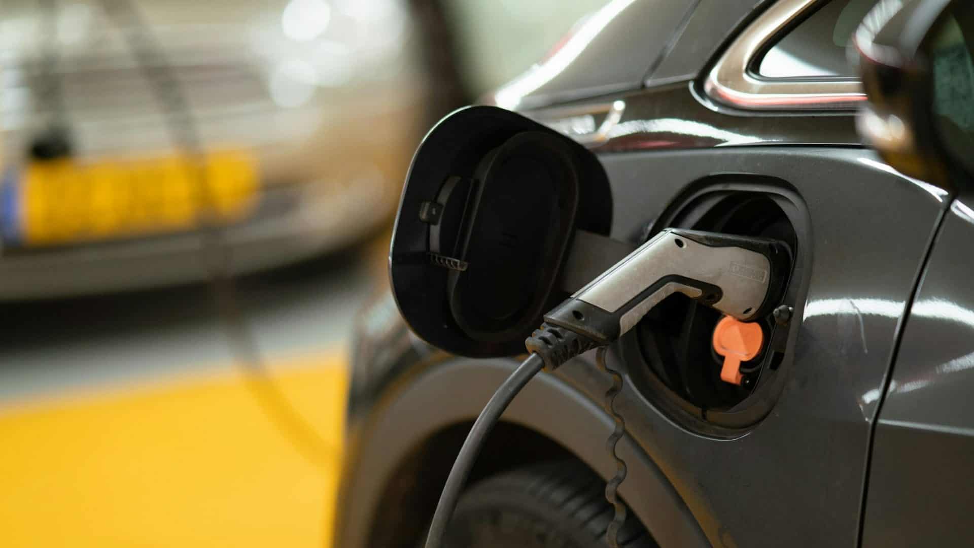 Carro elétrico na estação de carregamento via Michael Fousert/Unsplash