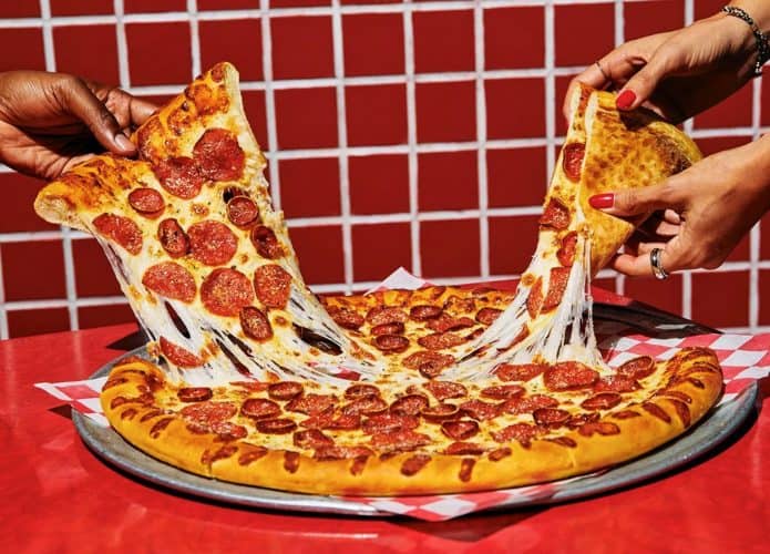 Pessoas pegando fatias de pizza do Pizza Hut