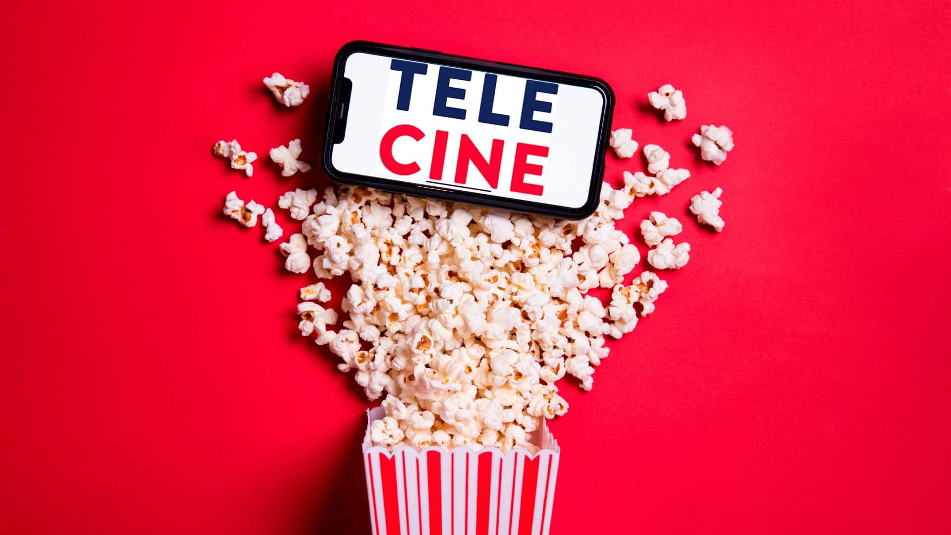 Pacote de pipoca com pipoca saindo e celular colocado em cima com logomarca do Telecine na tela