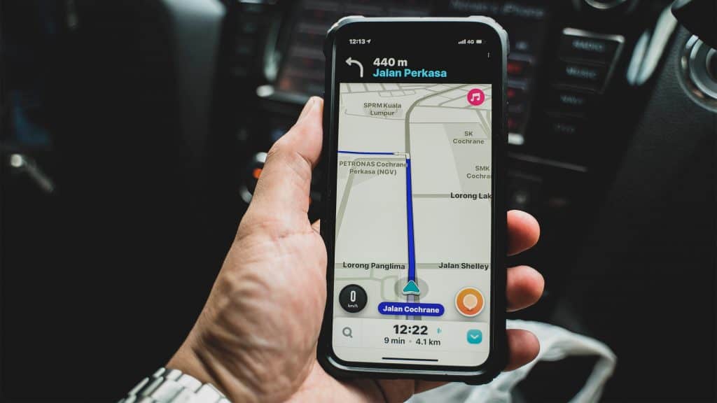 Pessoa usando Waze no celular dentro de um carro