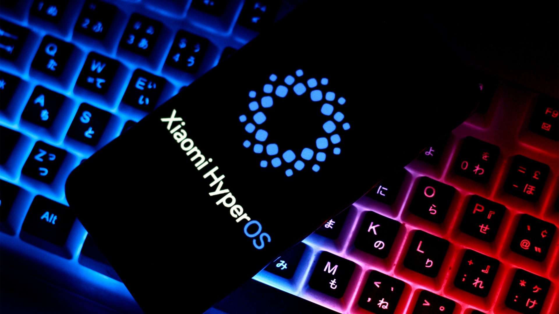 Celular com imagem do logotipo do Xiaomi HyperOS na tela, colocado sobre teclado com iluminação RGB azulada e rosada