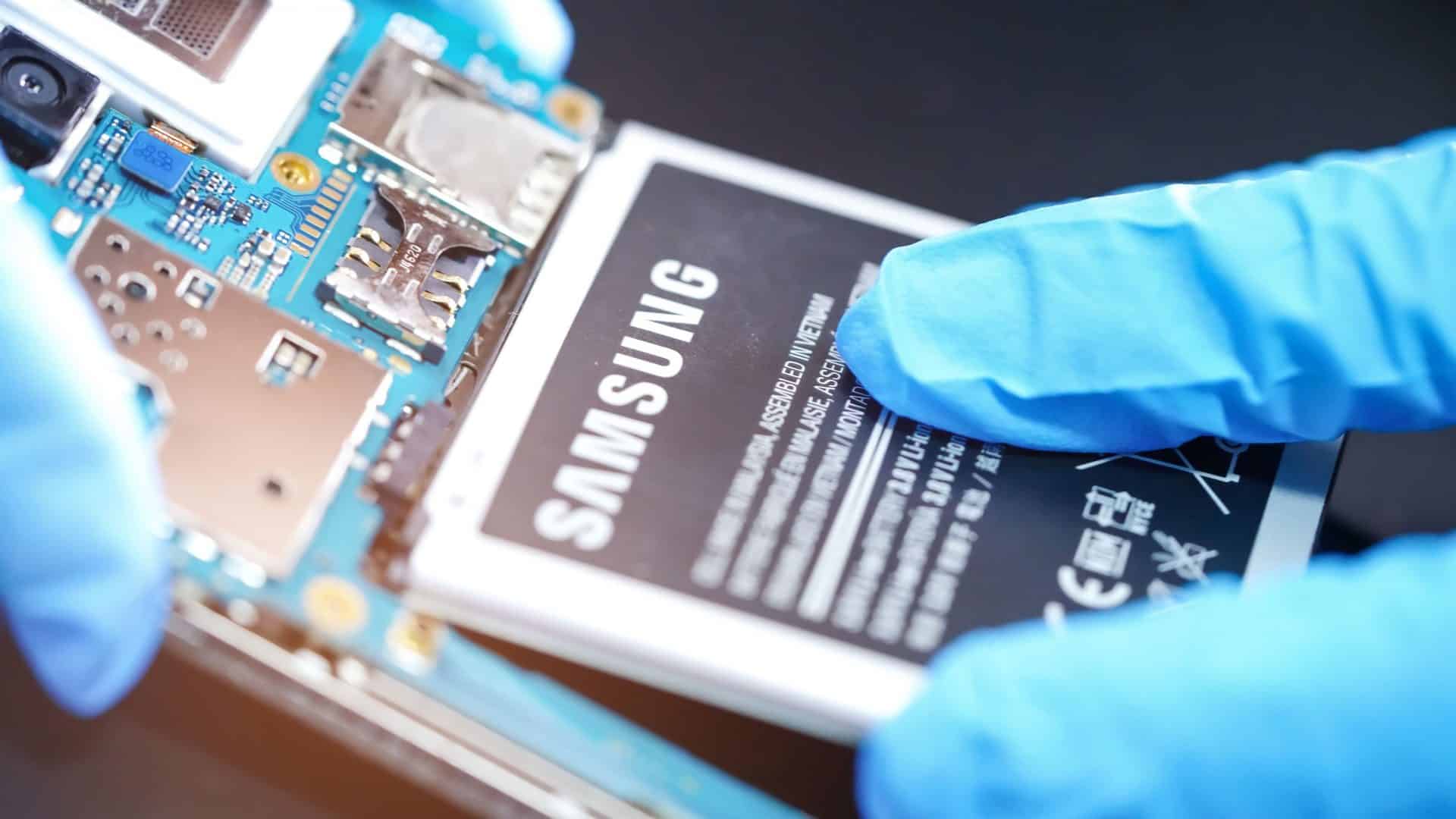 Imagem mostra mãos com luvas retirando bateria de celular Android para verificar saúde da bateria