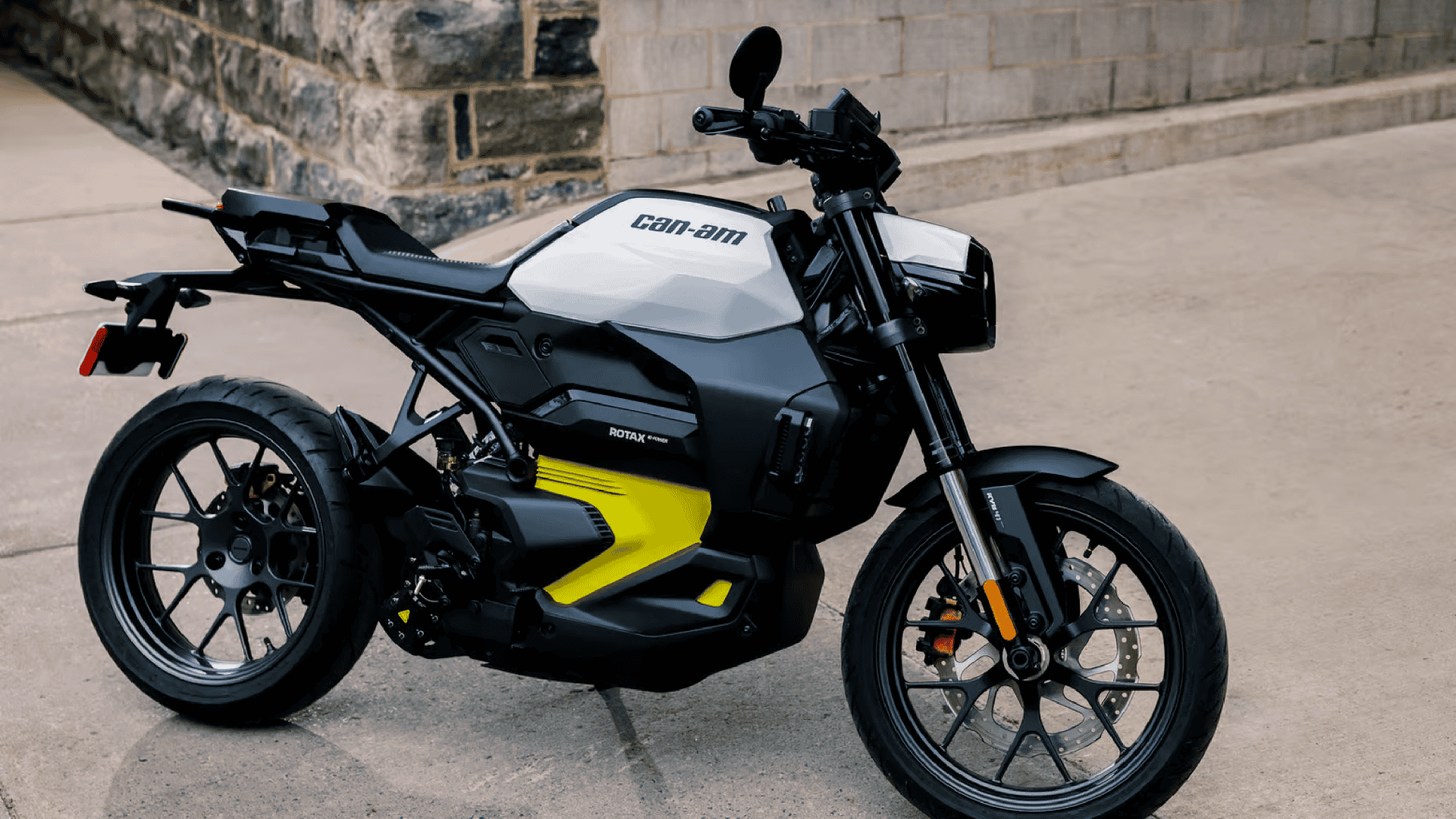 Imagem mostra a moto elétrica da Can-Am, um modelo preto com detalhes em amarelo