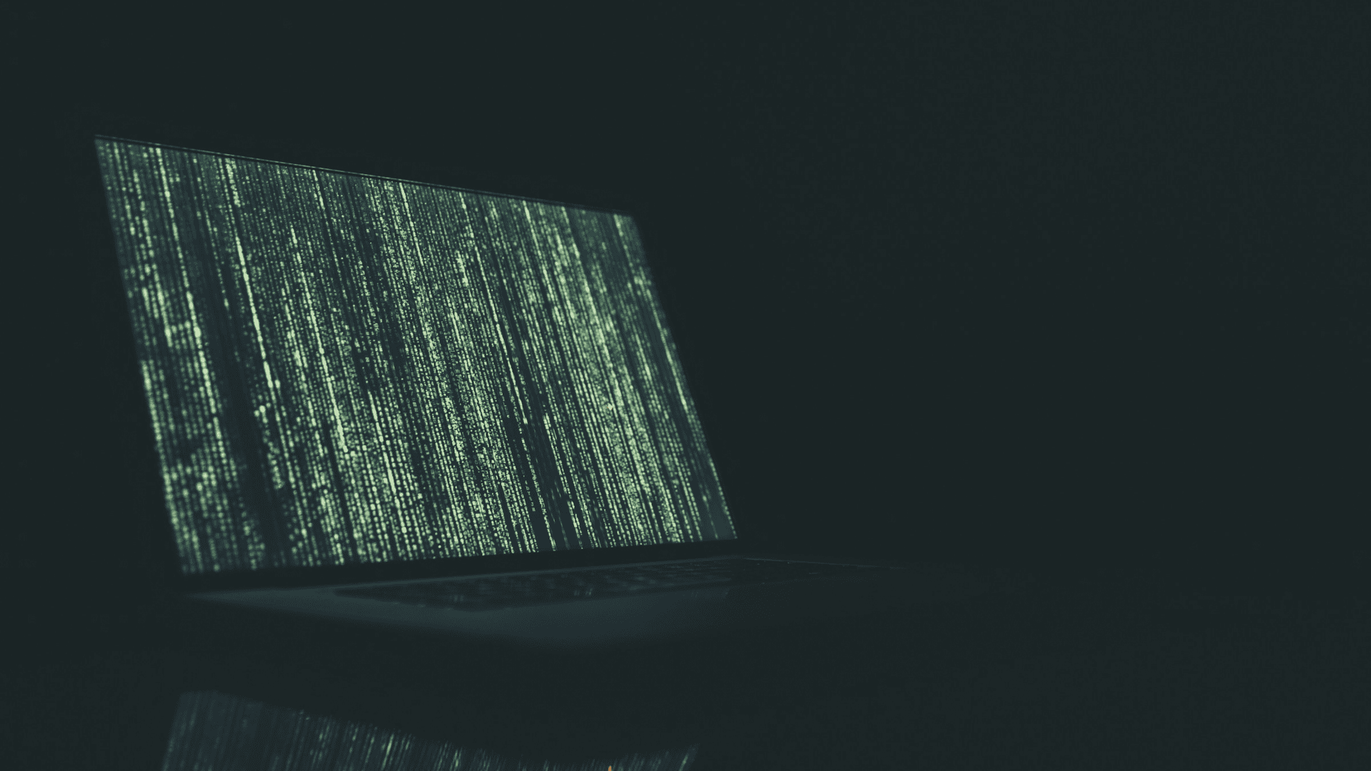 imagem mostra um notebook com tela criptografada cheia de códigos