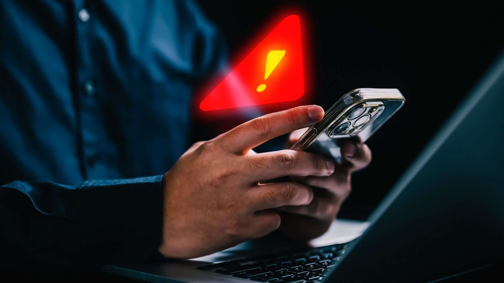 Símbolo de alerta acima de um celular que está sendo usado
