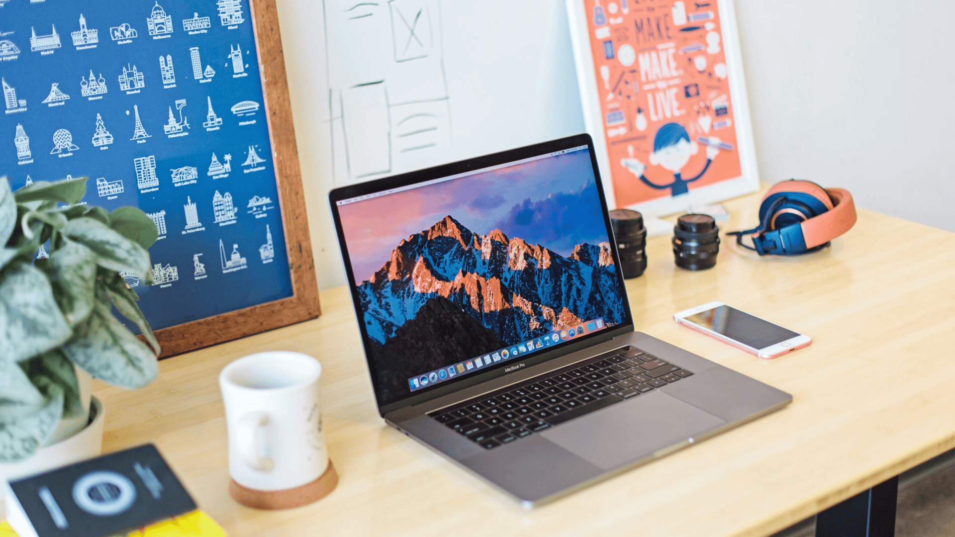 imagem ilustra um macbook em cima de uma mesa em um home office