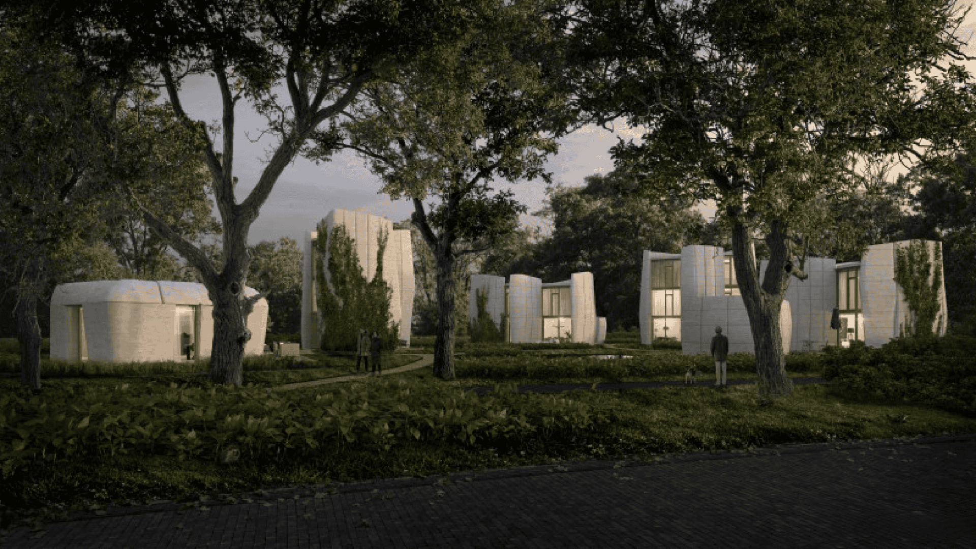 Imagem mostra um conjunto de casas impressas em 3D de dois e três andares. Em um primeiro plano da imagem, vemos árvores e uma rua pavimentada.