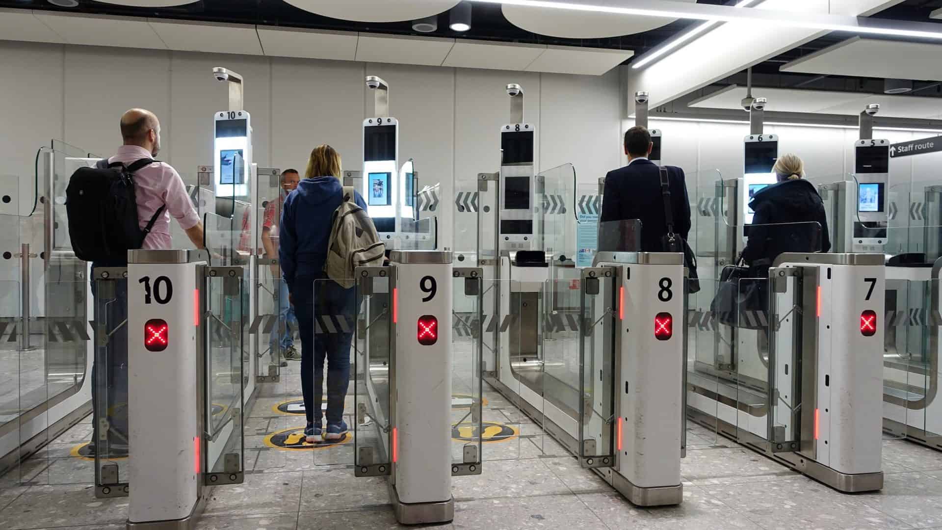 Imagem mostra uma série de catracas eletrônicas com reconhecimento facial e pessoas as utilizando