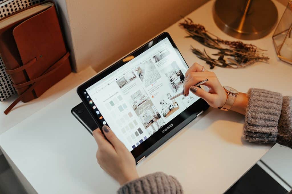 imagem mostra uma mulher utilizando uma caneta touch para mexer em um tablet grande da samsung