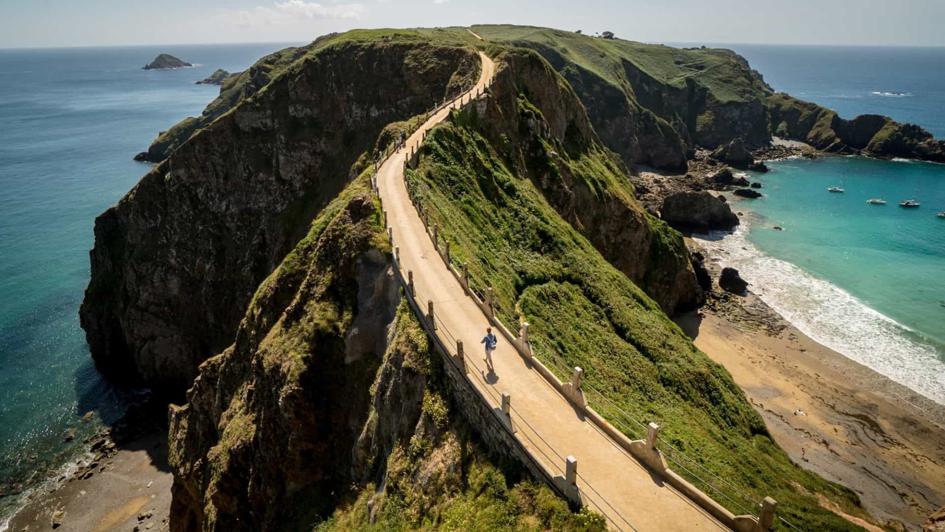 Foto de uma estrada nos penhascos sobre o oceano capturada na Ilha Sark