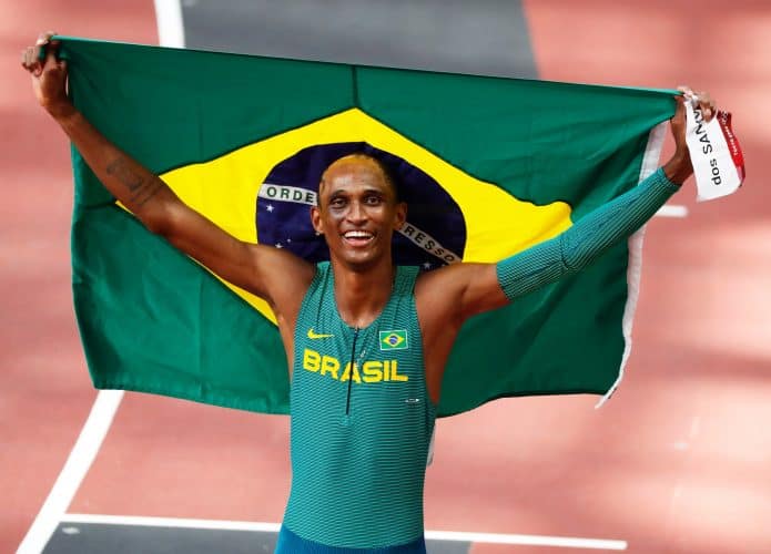 alison dos santos com a bandeira do brasil