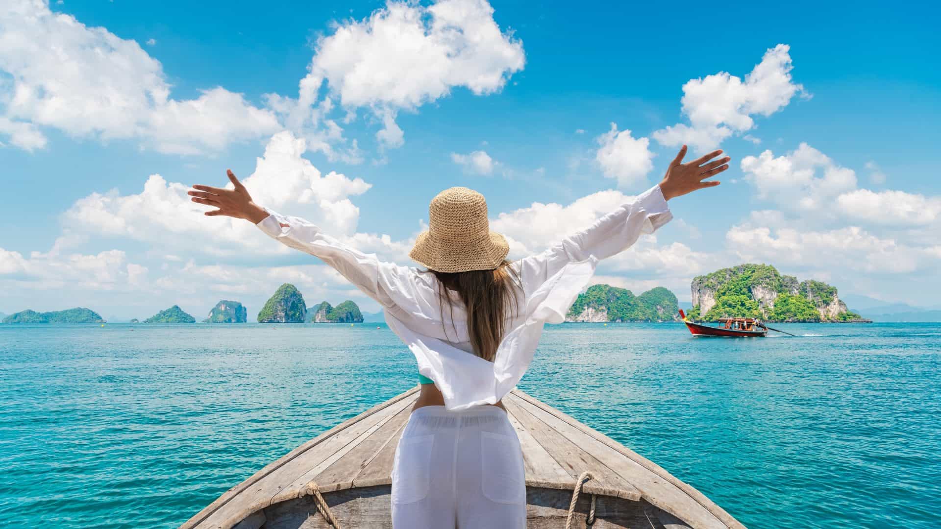Mulher viajante feliz em um barco, diversão na natureza, vista panorâmica de um grupo de pequenas ilhas no mar de Andaman, aventura de liberdade em Phuket, Tailândia, férias de verão, passeios, destino turístico na Ásia.