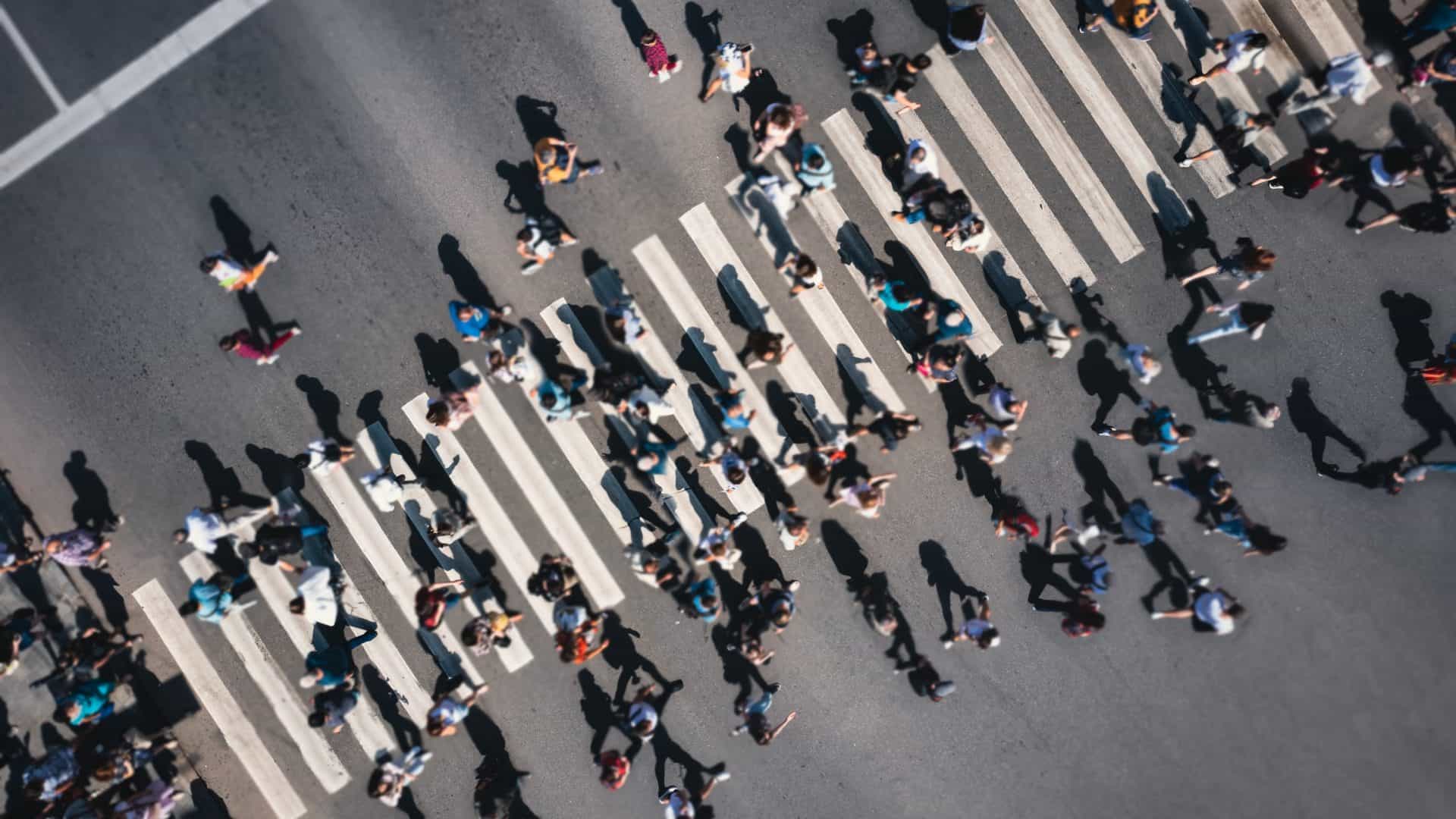 Vista aérea de pessoas atravessando uma faixa