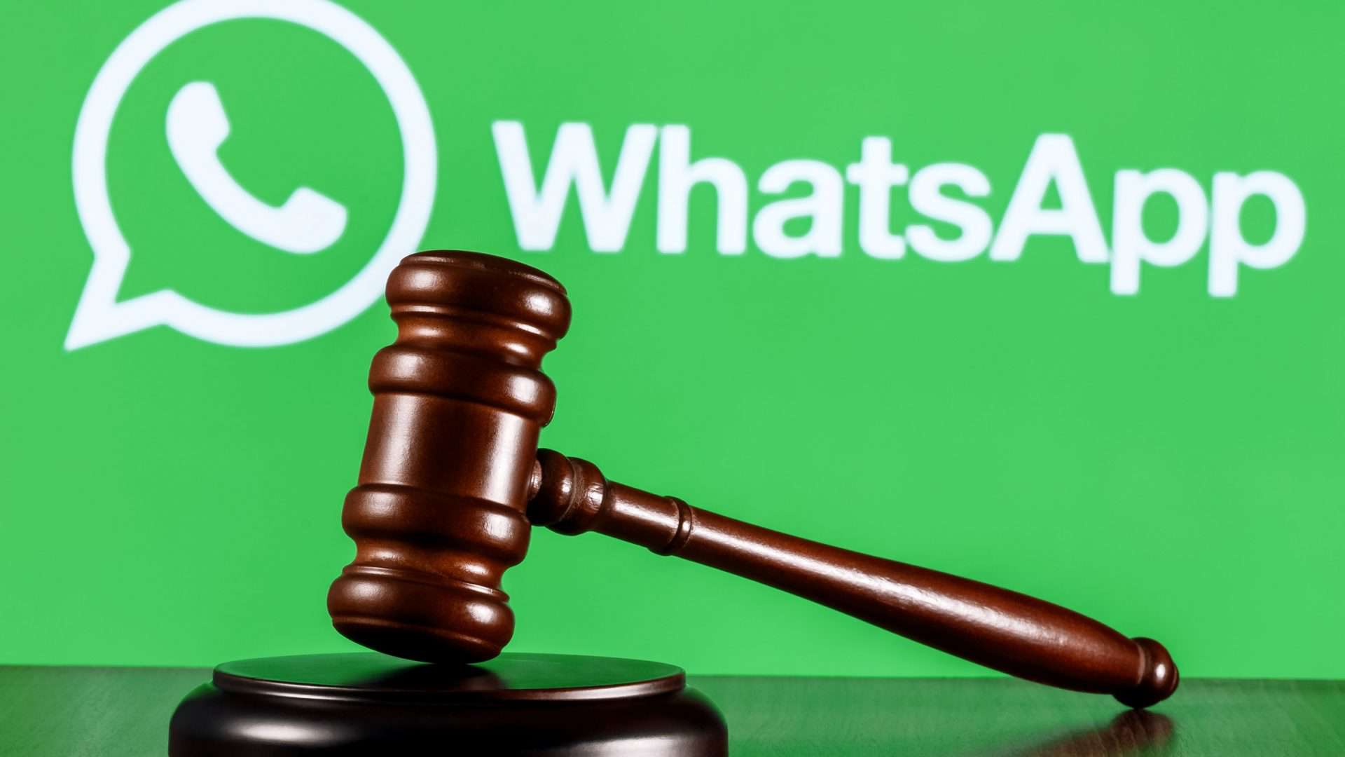 Martelo de juiz apoiado com logo do WhatsApp no fundo