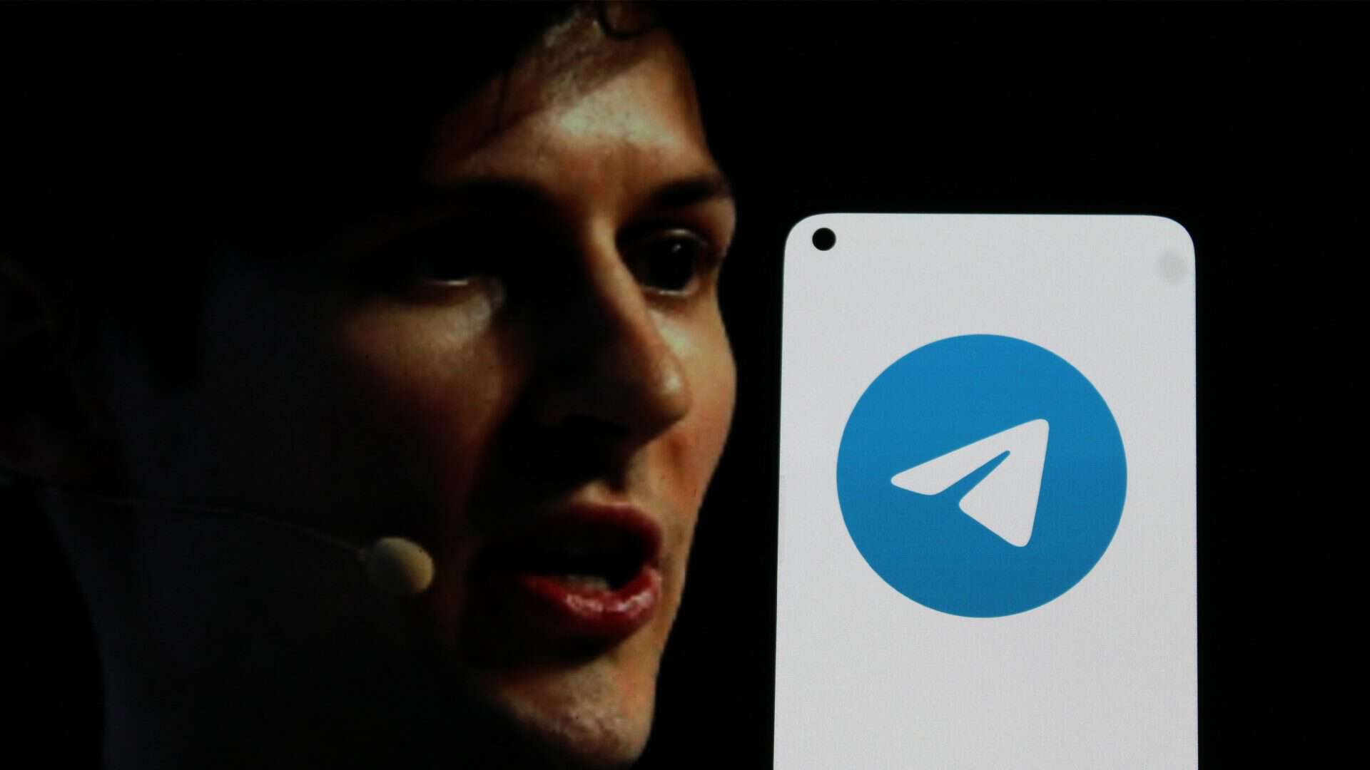 Celular com ícone do Telegram na tela e, ao fundo, uma foto de Pavel Durov, CEO do Telegram