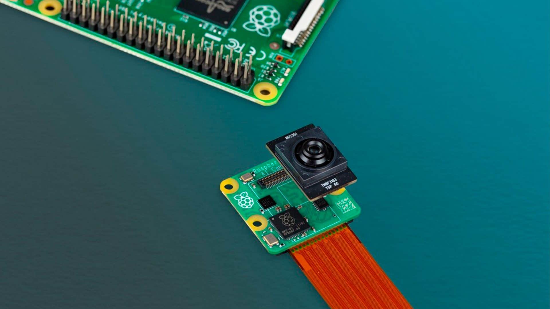 Camerazinha com IA da Raspberry Pi desenvolvida em parceria com a Sony ao lado de placa tecnológica da marca