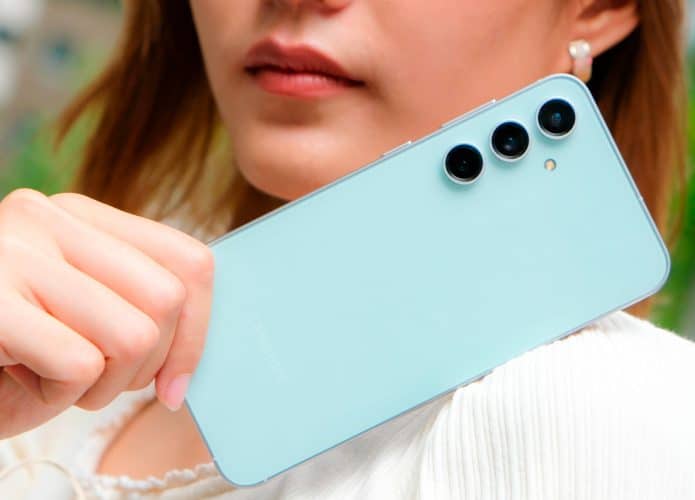 Mulher segurando celular Samsung Galaxy S23 FE ao lado do rosto