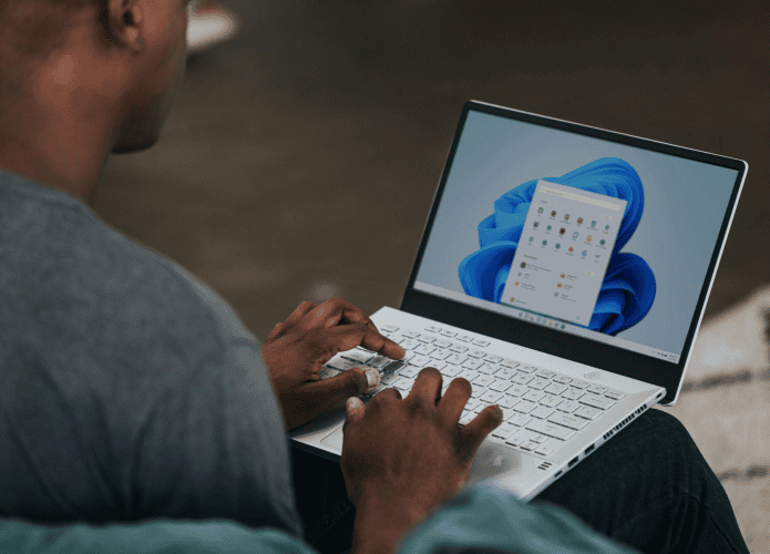 Homem mexendo em um notebook com Windows 11