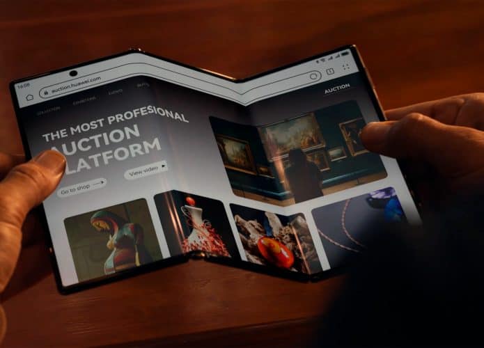 Pessoa segurando Huawei Mate XT aberto com página aberta em navegador