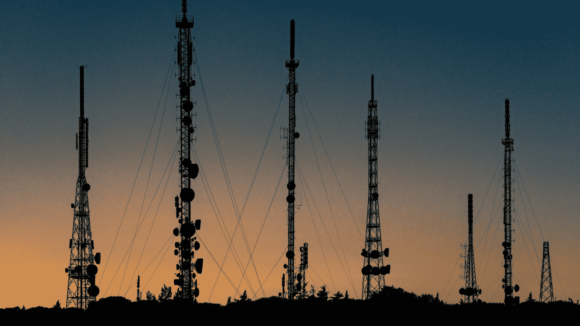imagem mostra grandes antenas de telecomunicação e um pôr-do-sol ao fundo