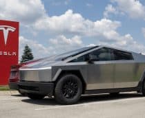 Tesla Cybertruck ao lado de uma placa vermelha com o logo da Tesla