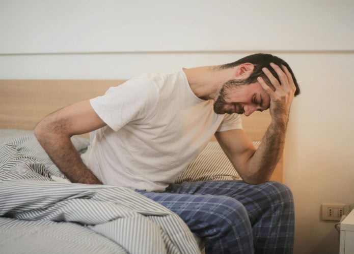 Jovem Em Pijamas Com Dor De Cabeça Pela Manhã