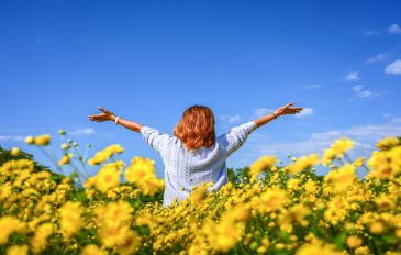 Jovem feliz curtindo um campo de crisântemos amarelos.