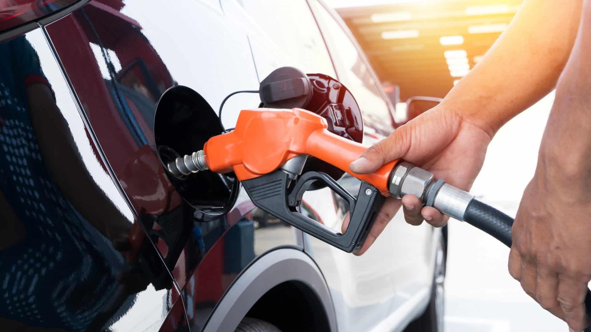 Reabastecendo o carro na bomba de combustível de um posto de gasolina.