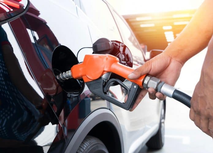 Reabastecendo o carro na bomba de combustível de um posto de gasolina.