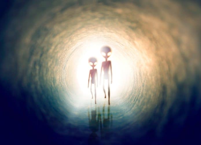 Ilustração de dois alienígenas contra a luz andando em túnel escuro