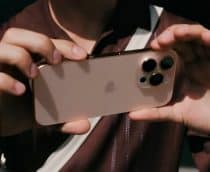 Pessoa segurando iPhone 16 Pro na horizontal com dedo sobre botão de Controle da Câmera