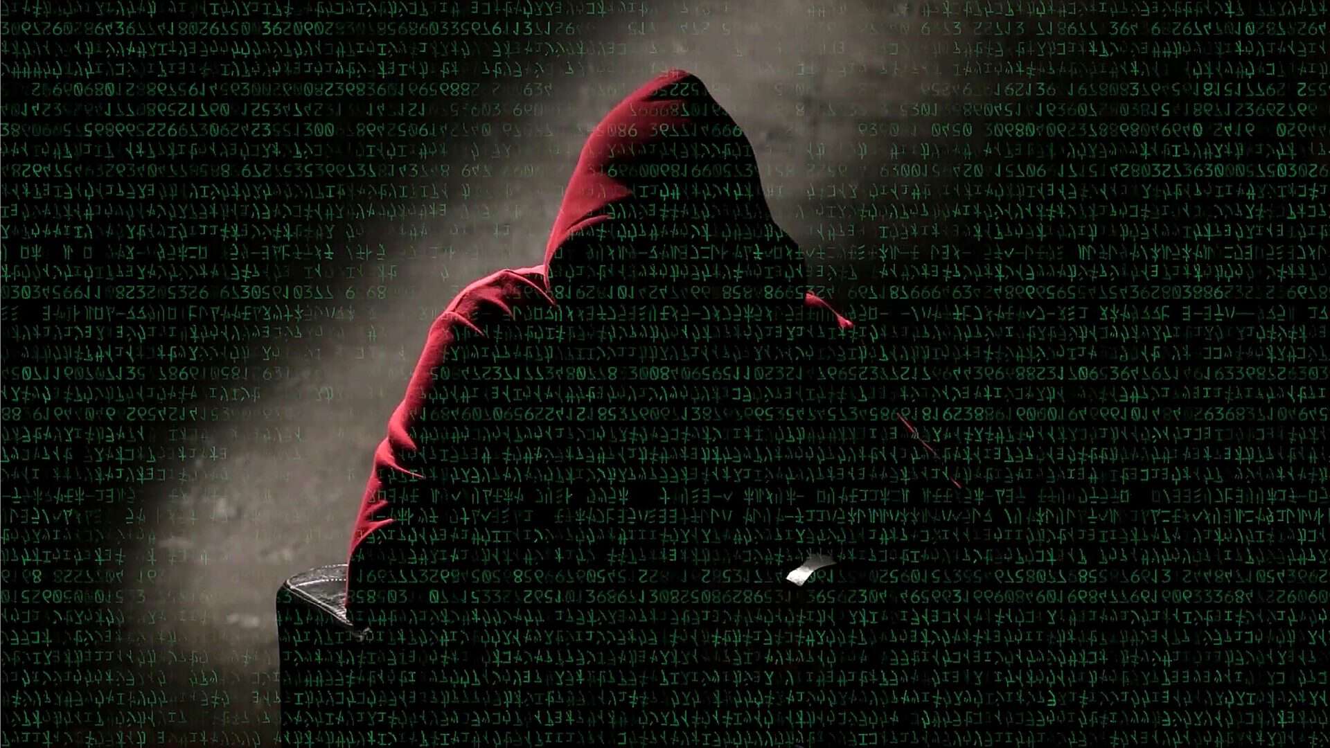 Ilustração de hacker usando moletom vermelho e sobreposto por linhas de programação com letrinhas verdes
