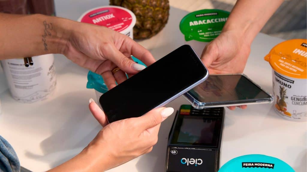 Pessoa aproximando celular de outro celular para ilustrar funcionamento do Pix por Aproximação lançado pelo Banco do Brasil