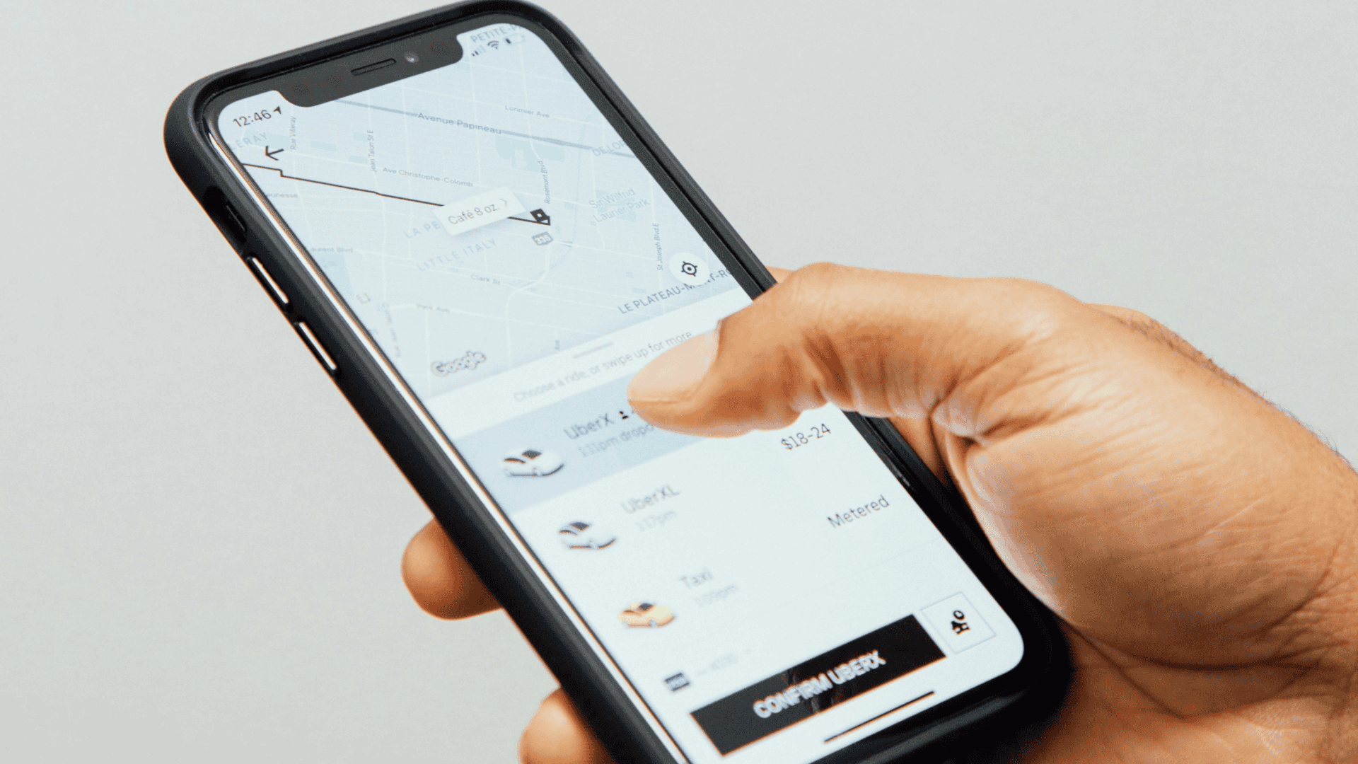 imagem mostra uma pessoa usando o aplicativo de celular Uber para chamar um carro