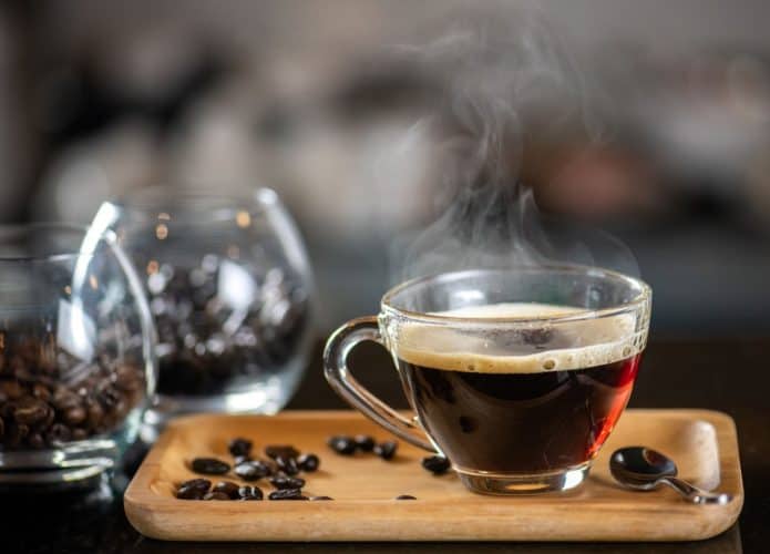 Xícara de café e alguns grãos