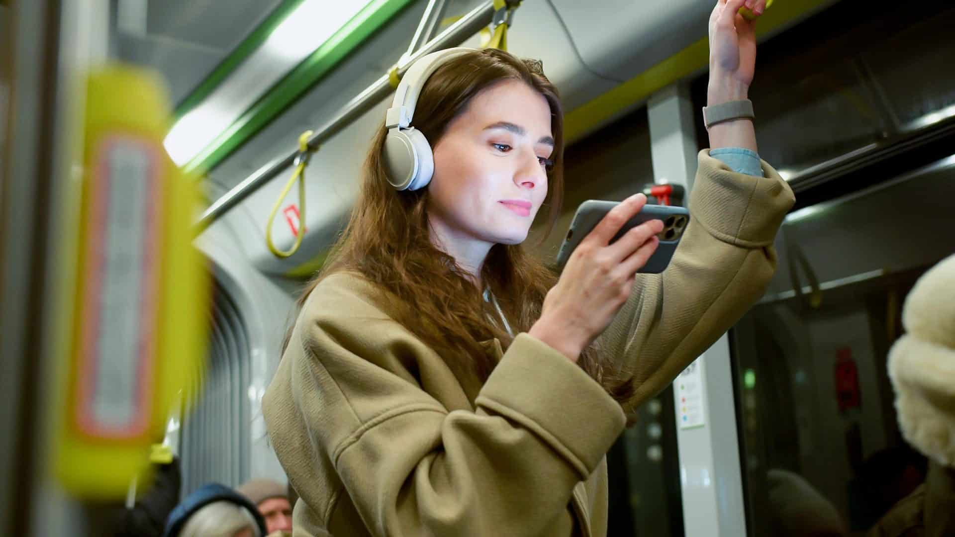 Pessoa usa fones de ouvido em transporte público