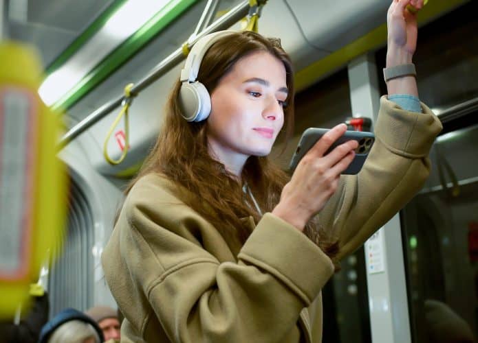 Pessoa usa fones de ouvido em transporte público