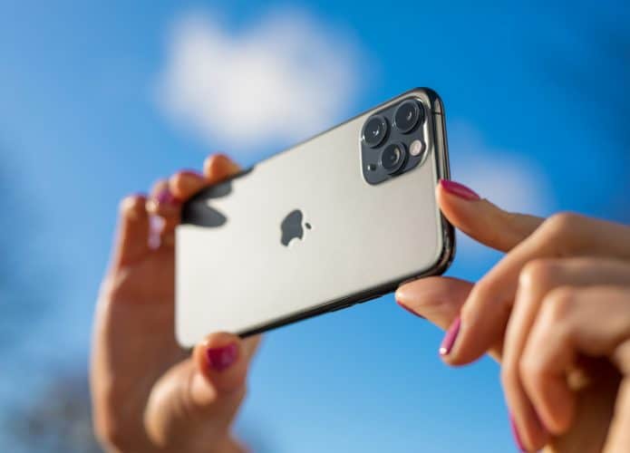 mãos de uma pessoa com um iphone na mão enquanto tira uma foto