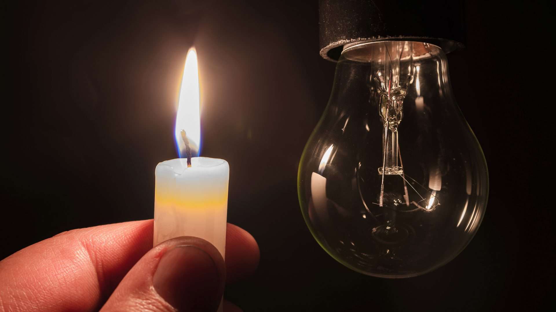 lâmpada apagada e uma vela acesa