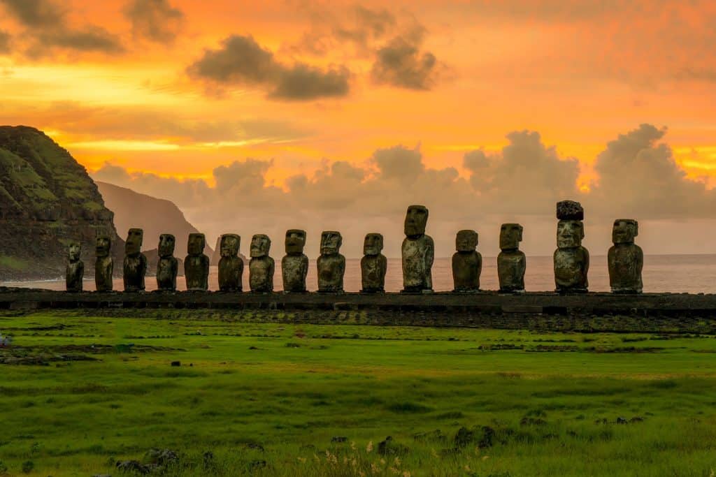 Estátuas de pedra, ao longe, no alvorecer na Ilha de Páscoa