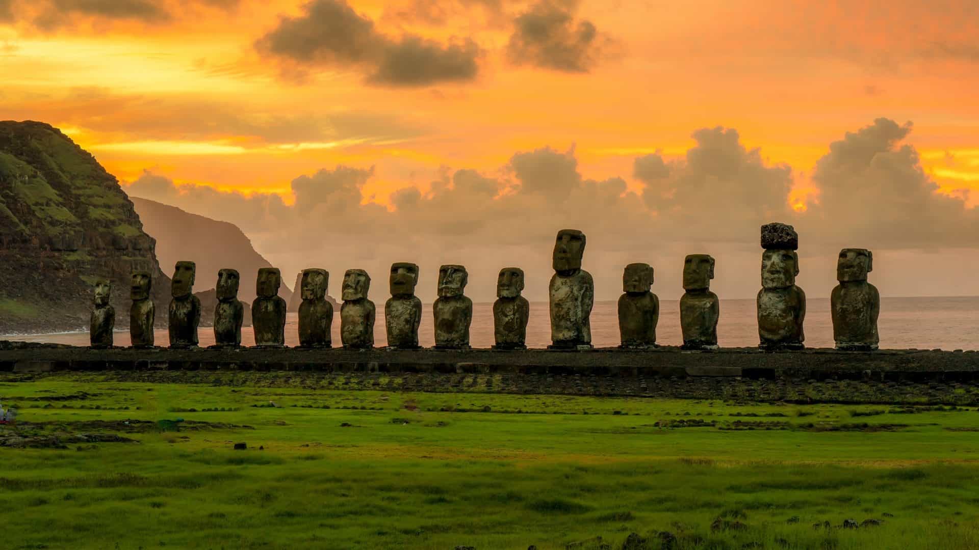 Estátuas de pedra, ao longe, no alvorecer na Ilha de Páscoa