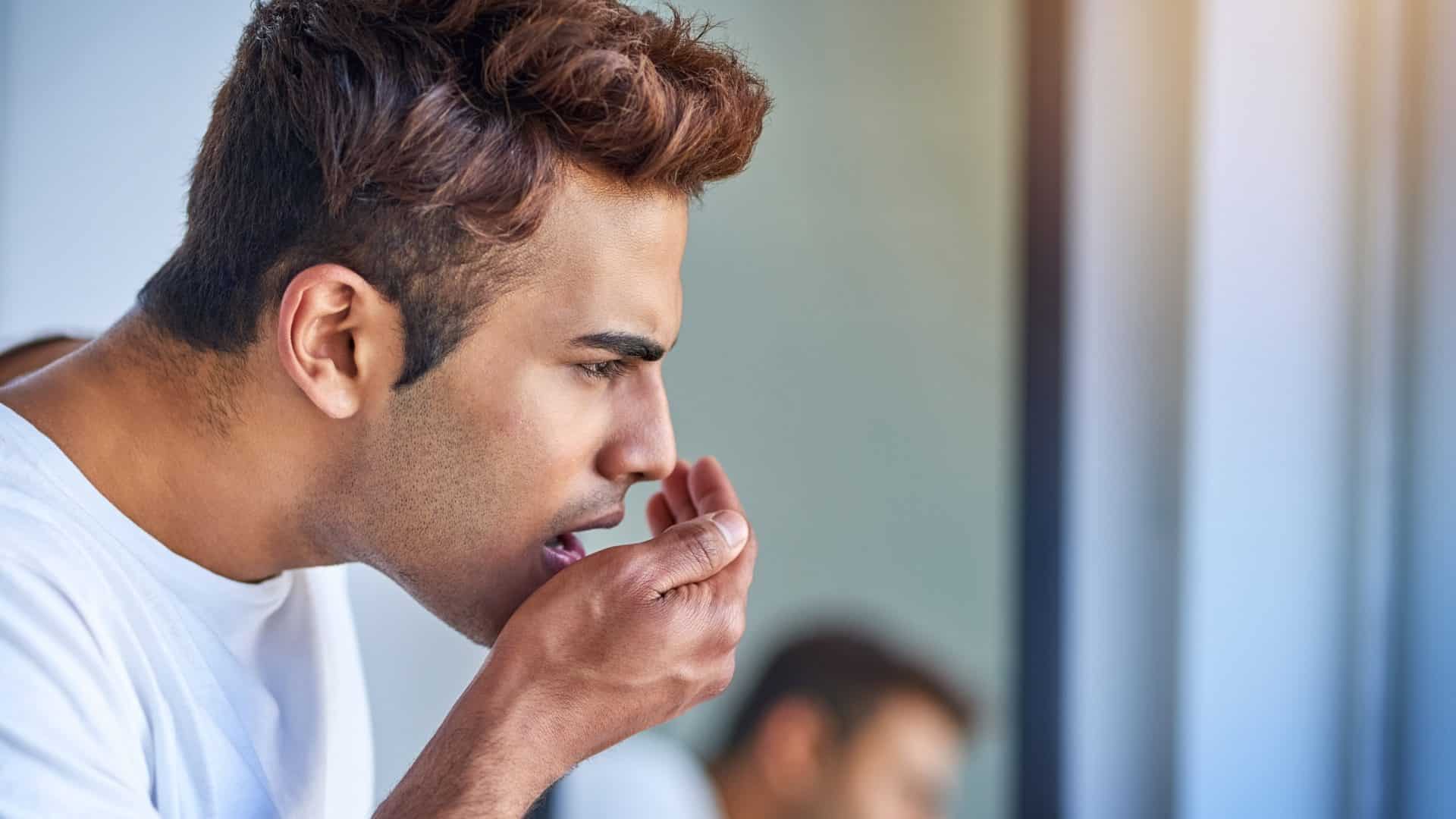 Homem cheirando a própria boca