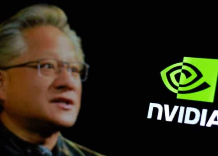 Foto de CEO da Nvidia ao lado de logomarca da empresa