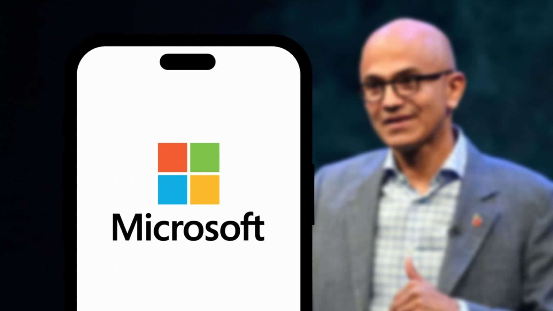 Satya Nadella ao lado de um smartphone exibindo o logo da Microsoft em sua tela
