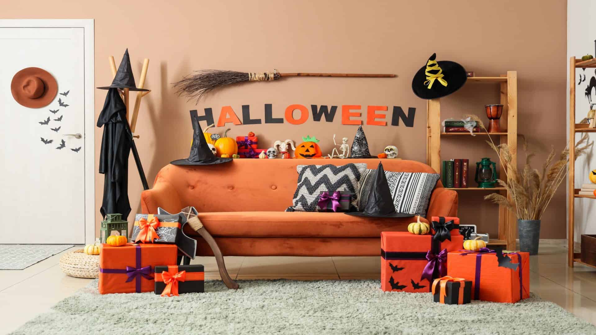 Interior da sala de estar decorada para a festa com sofá, enfeites de Halloween e caixas de presente