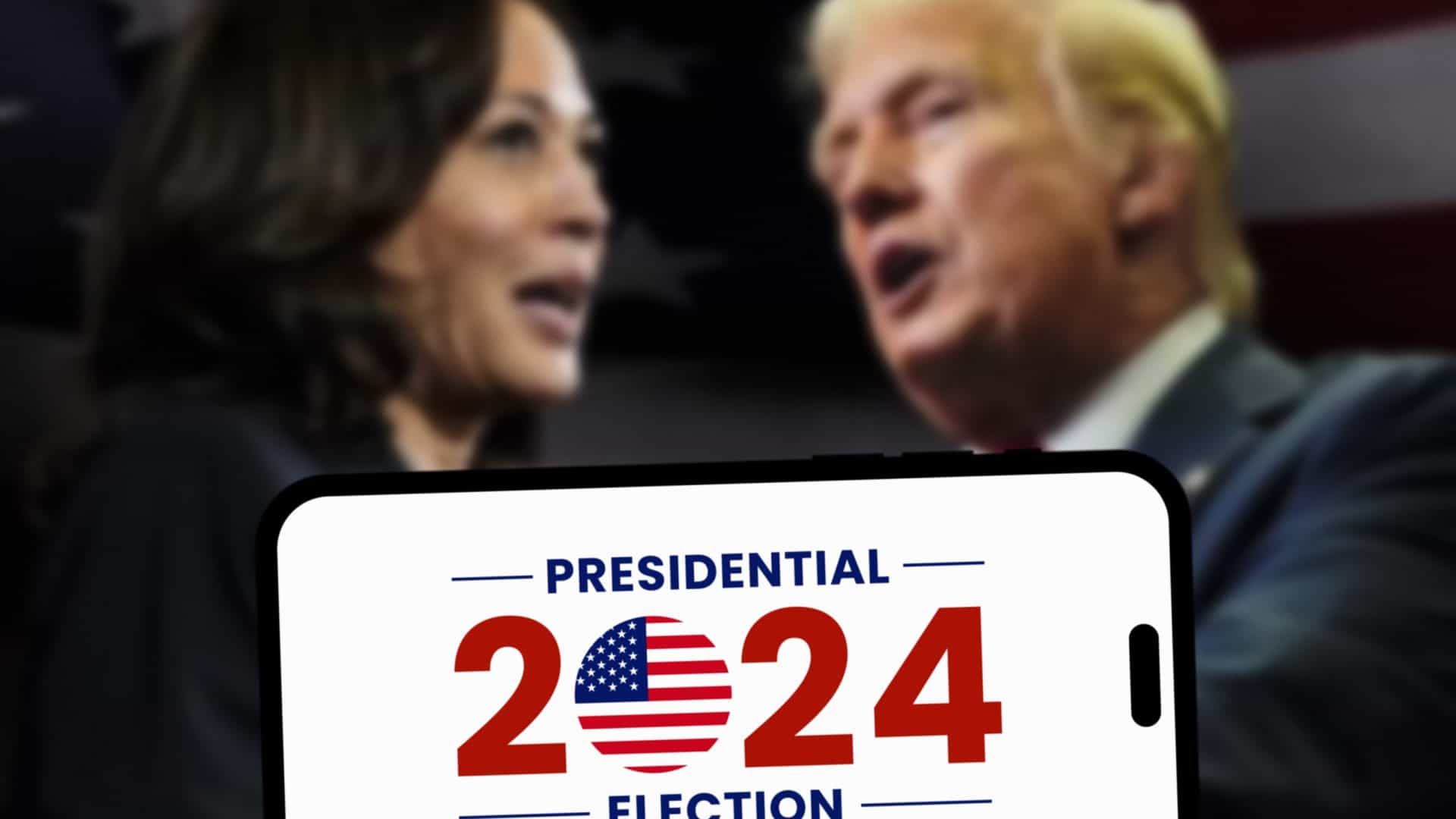 Rostos de Harris e Trump desfocados, com a frase 2024 Presidential Election sendo exibida à frente em um smartphone
