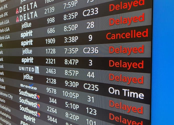 Painel de areroporto mostrando voos cancelados, atrasados e no horário