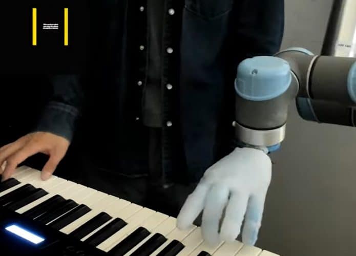 Mãos humana e de robô tocando um piano